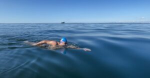 Swimmer Aryan Dadiala in calm water near large ships